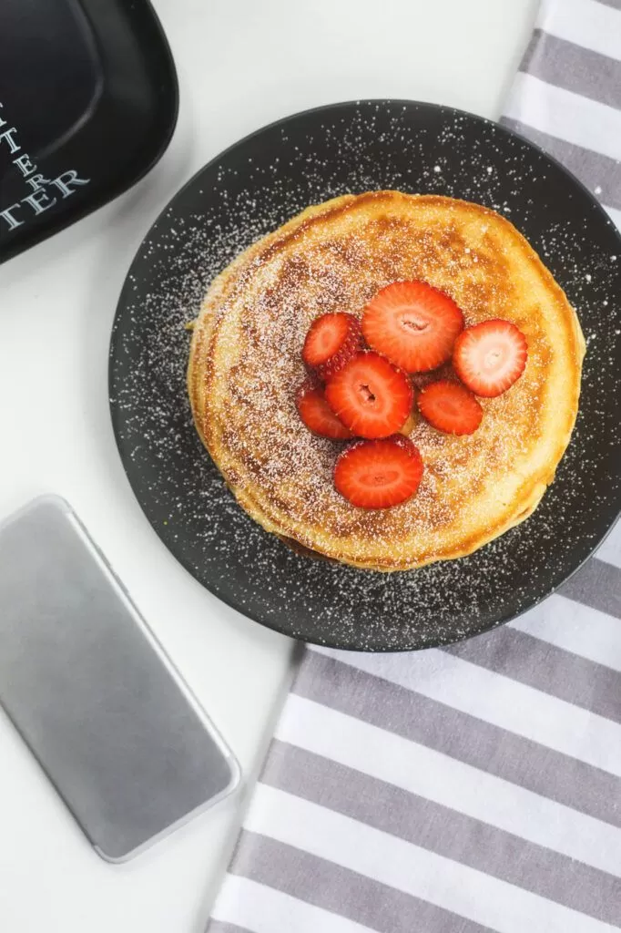 Pancakes in a skillet with strawberry toppings